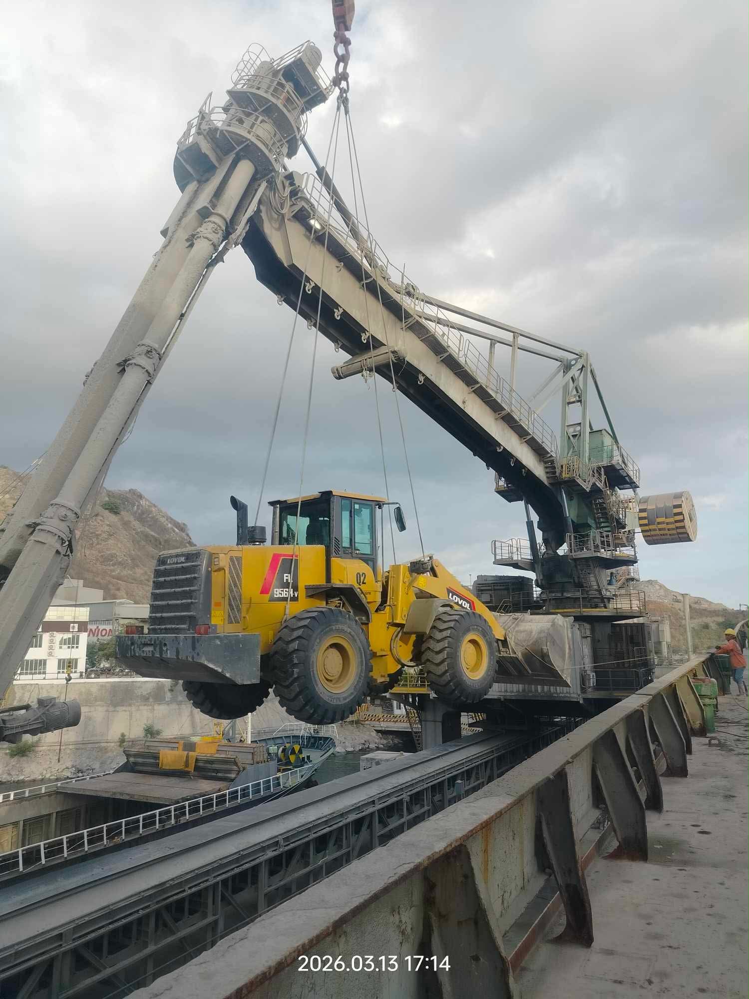 Wheel loader suspended from crane at the port