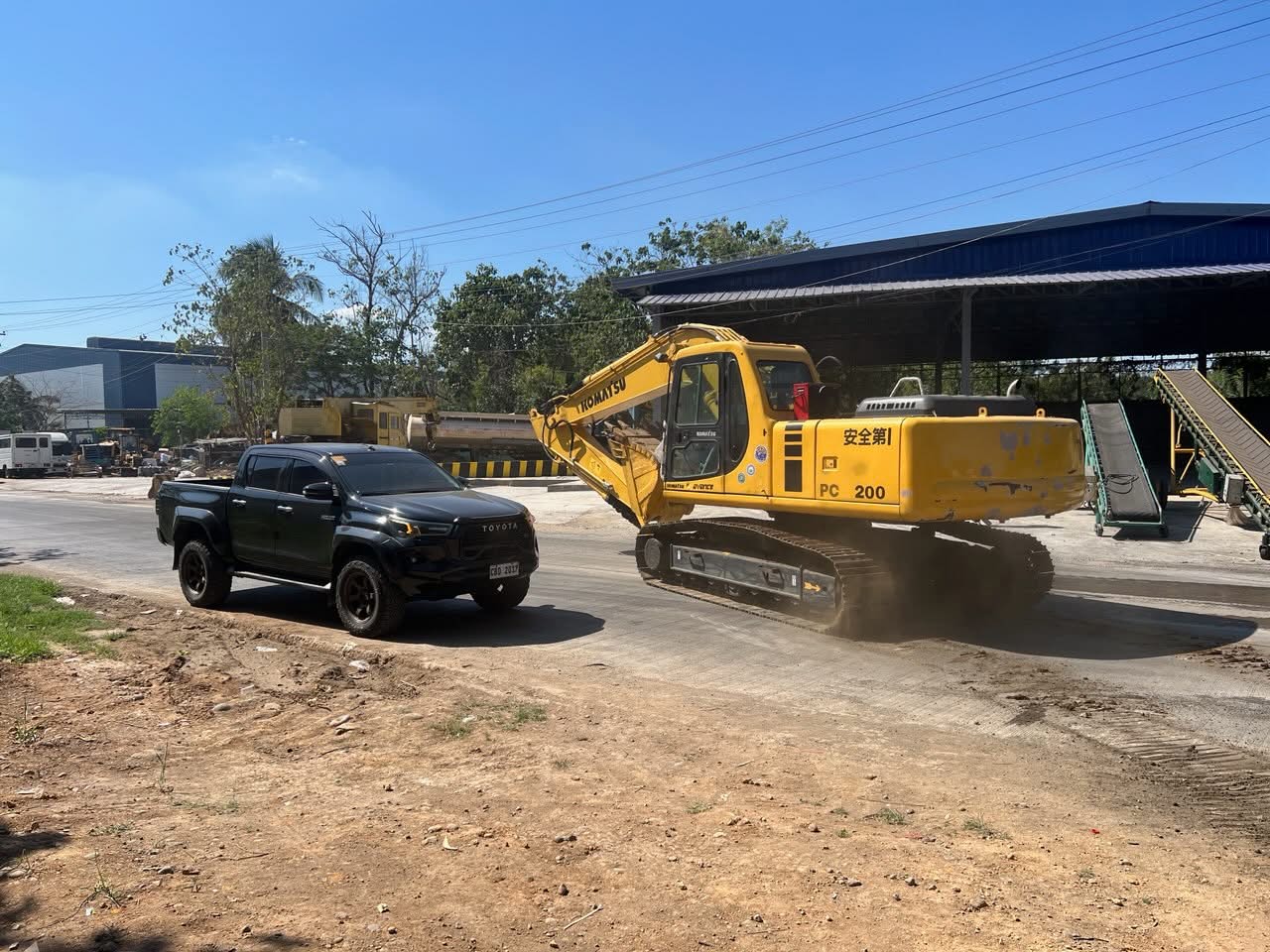 Two wheel loaders positioned beside a vessel and covered structure