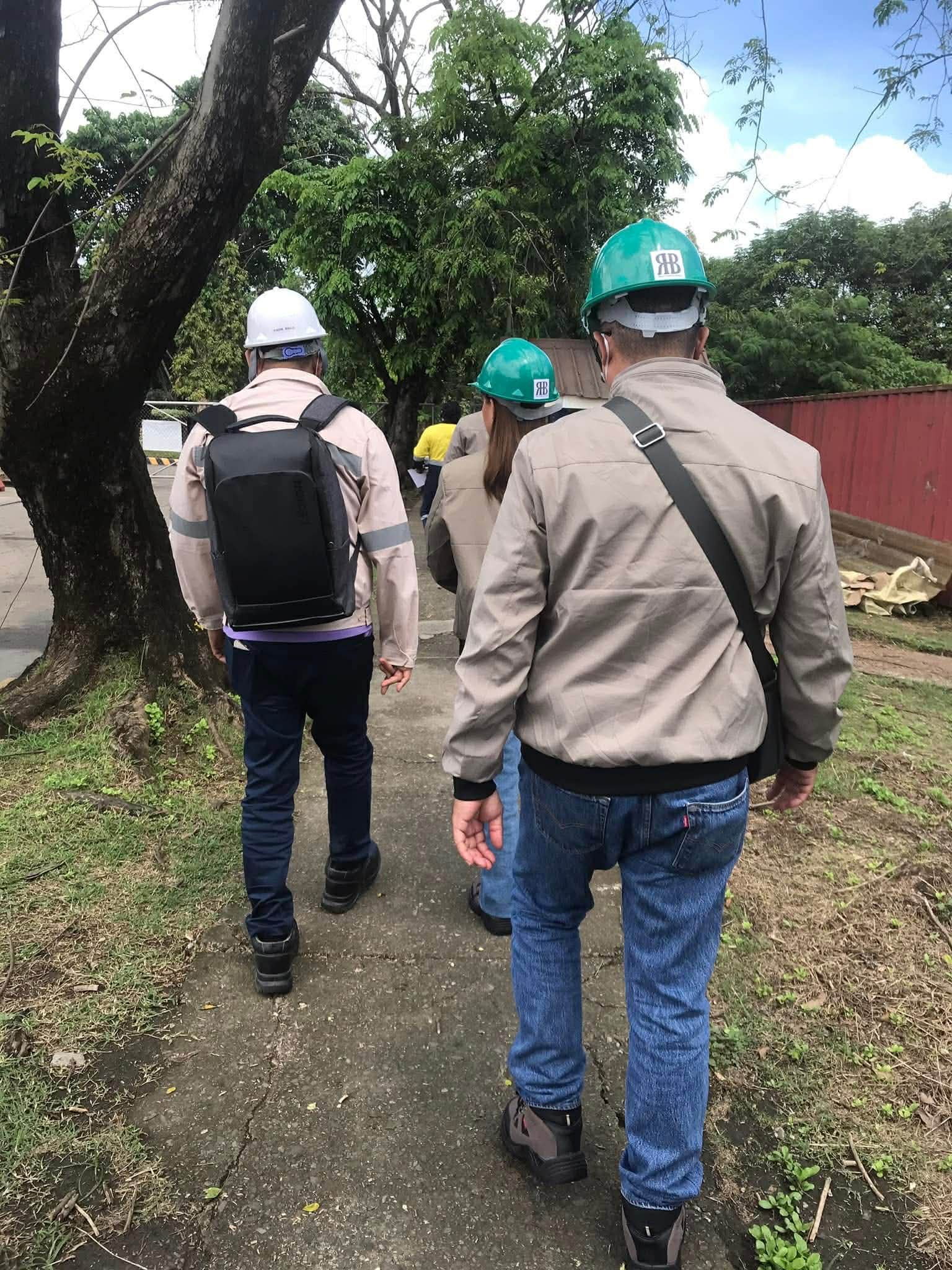 HBR personnel walking through a field site in safety helmets