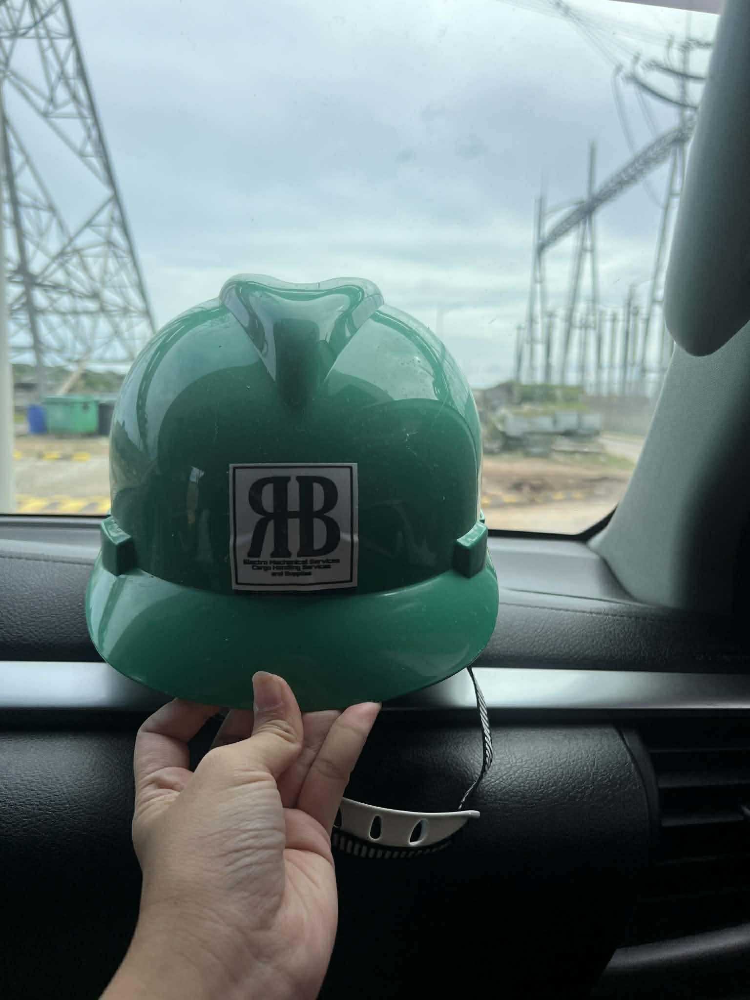 HBR hardhat displayed inside a vehicle near an industrial site